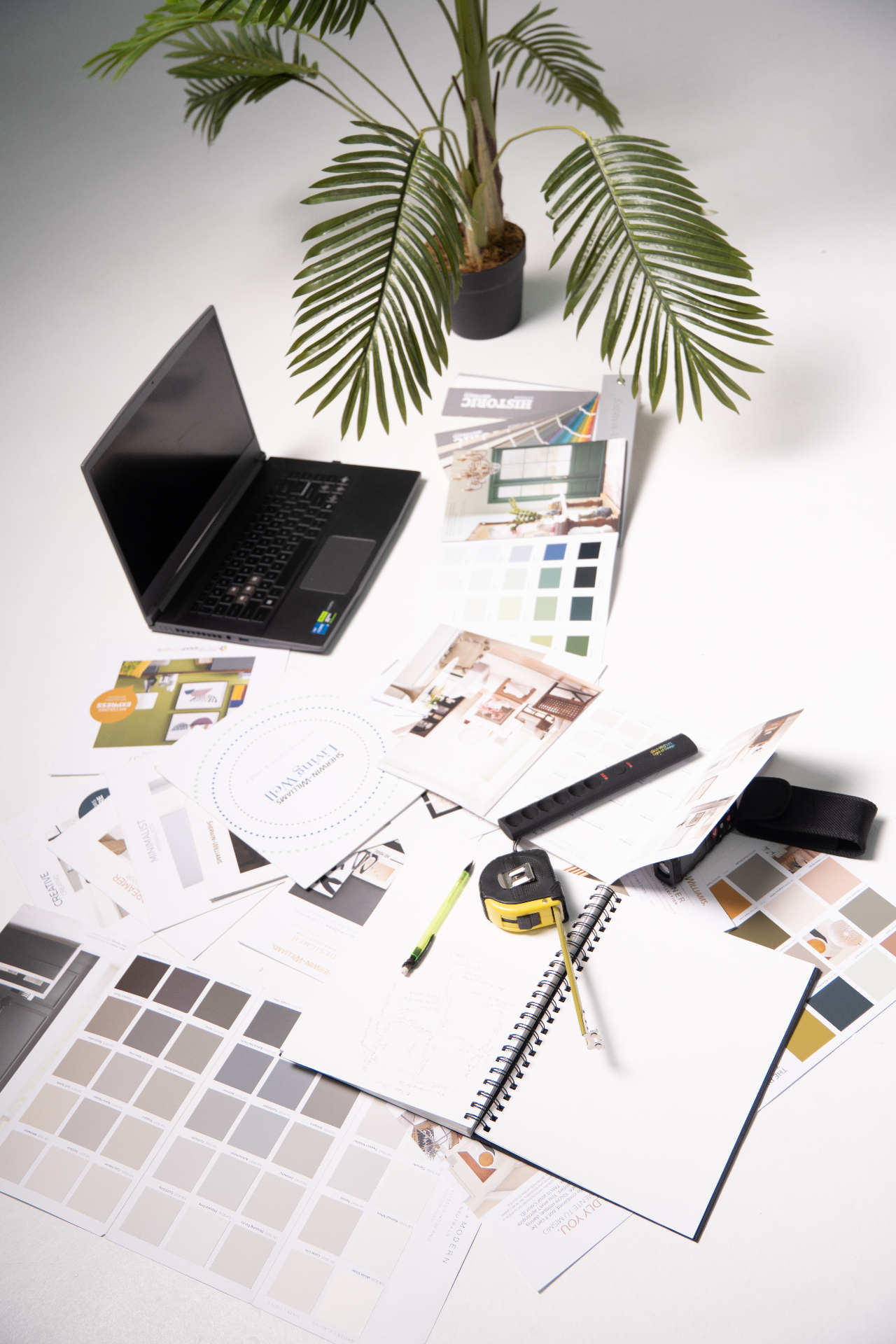 Interior design workspace with color samples, laptop and drafting tools