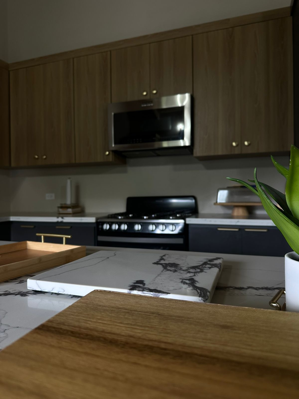 Marble island, matte navy cabinetry and brass hardware in a chef's kitchen.
