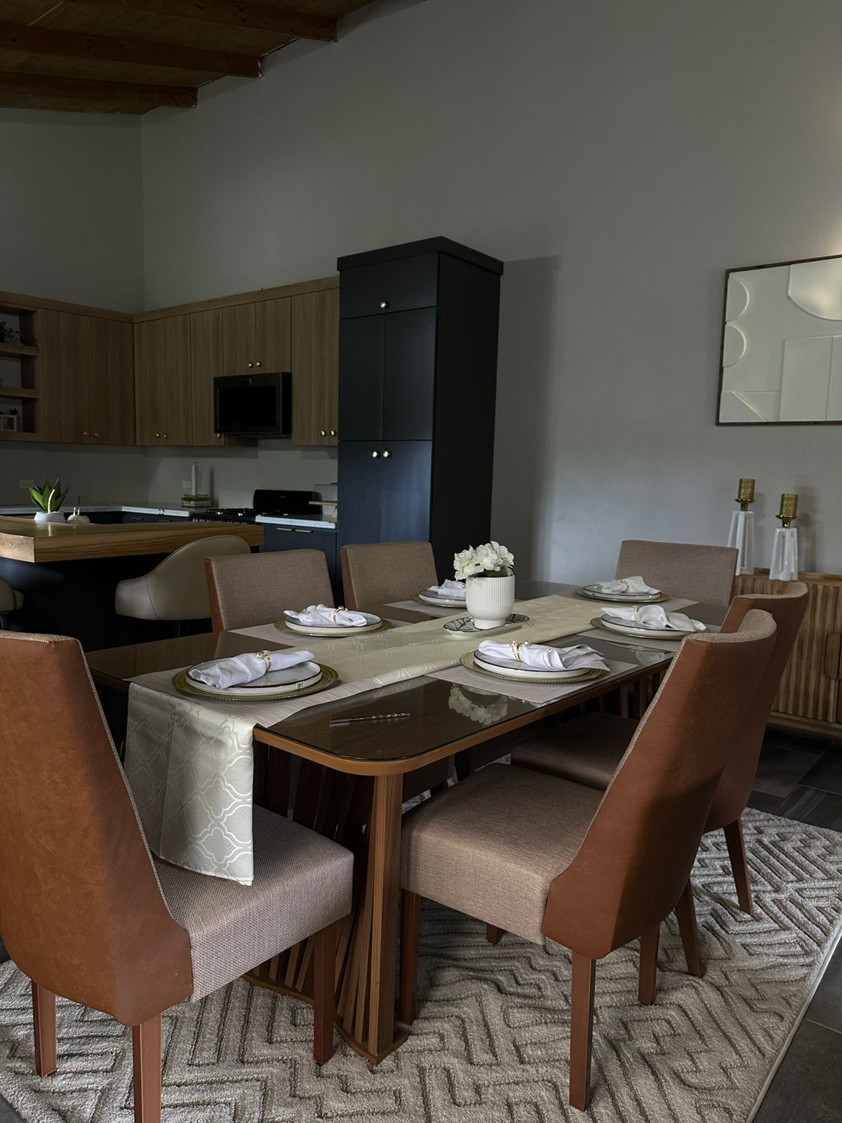 Tailored dining setting with linen runner, gold accents and warm wood tones.
