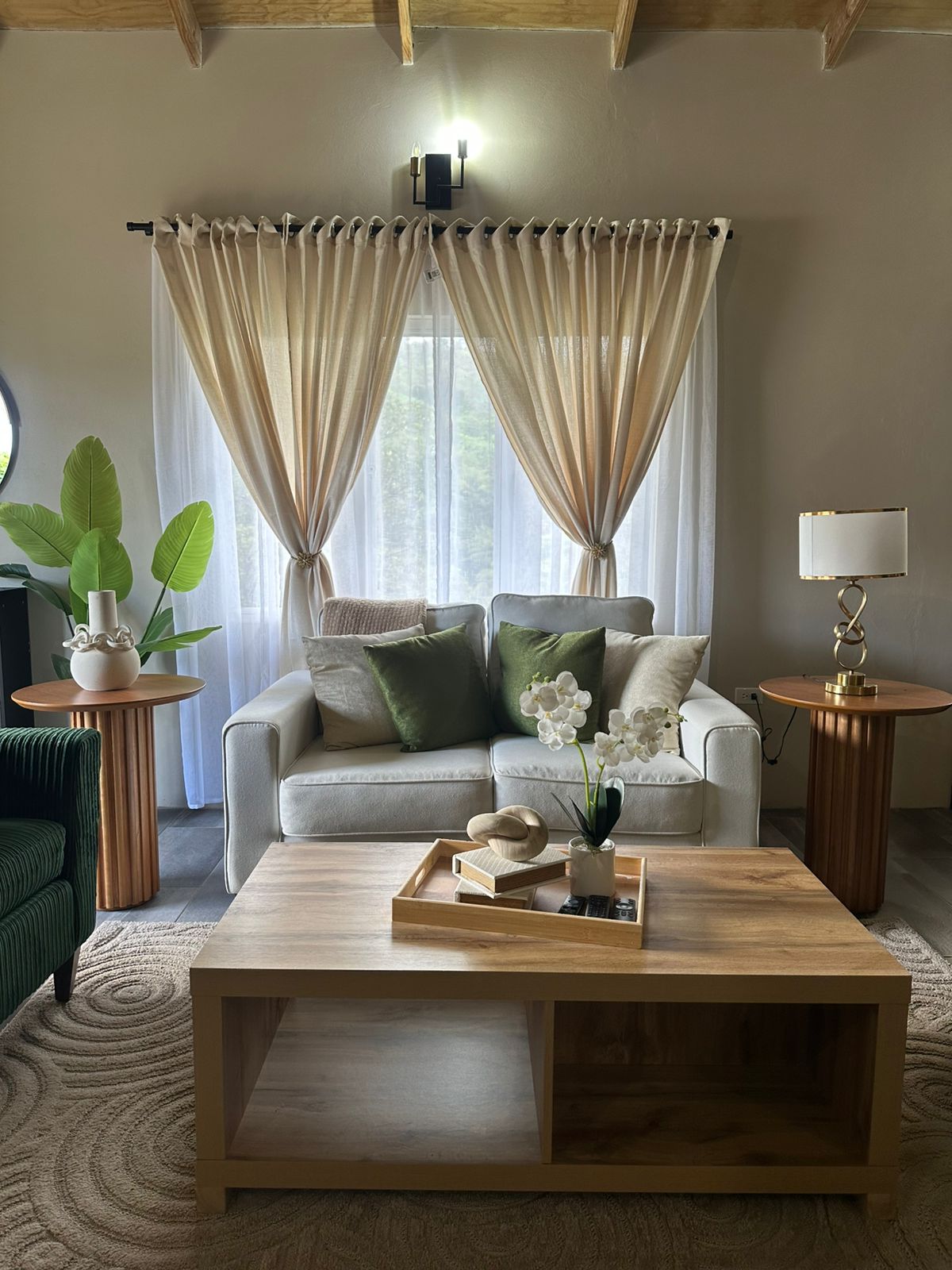 A serene living room layered in linen, olive velvet and warm wood.