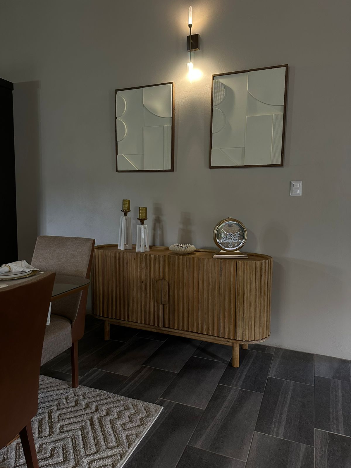 A quiet dining vignette with fluted wood console and sculptural mirrors.